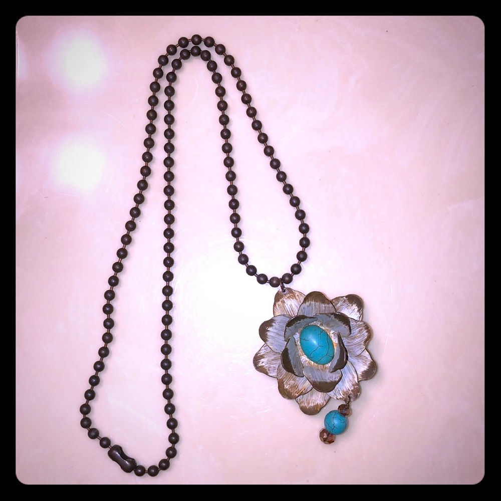 Long chained necklace with a flower pendant